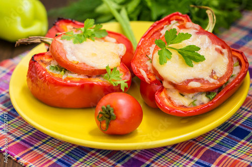 Stuffed bell peppers with rice and cheese. Wooden background. Close-up