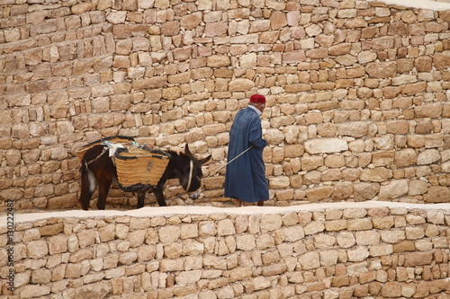 Man and donkey in hillside Berber village of Chenini, Tunisia photo