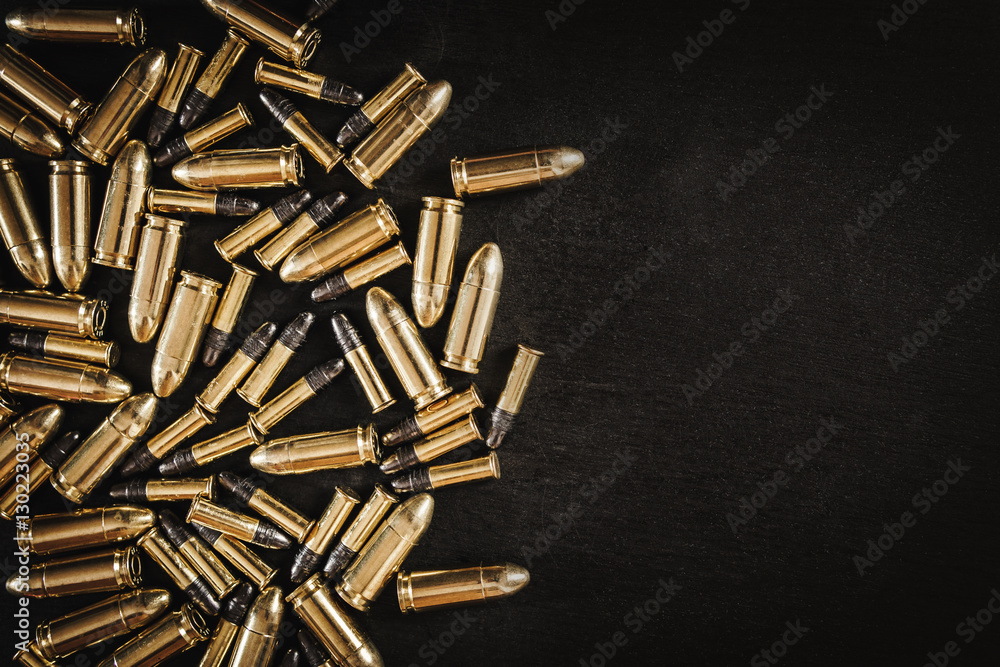 bullets from the gun placed on a black wooden table
