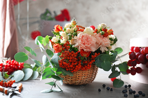 Beautiful flower composition with berries on table