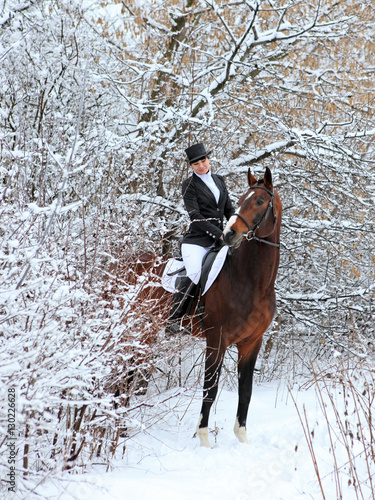 Horseback - woman riding a horse. Horse and equestrian girl in winter outside