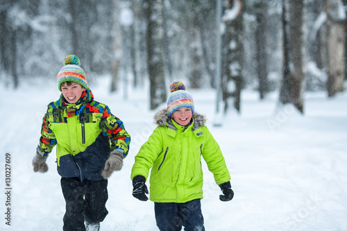 cheerful happy boys playing in winter park,