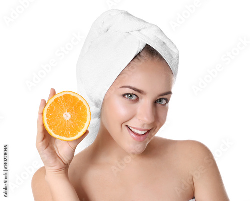 Beautiful young woman holding sliced orange on white background
