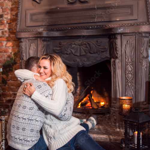 Man and a woman in warm knitted sweaters, hugging