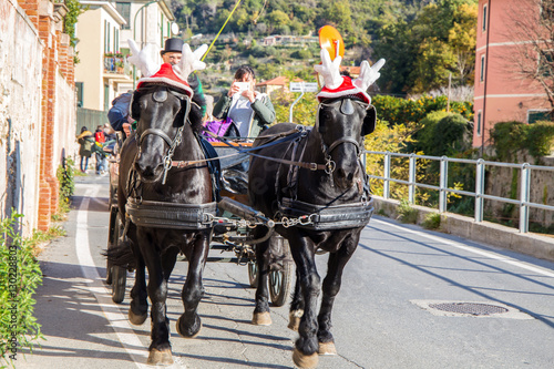 Canvas Print FINALE LIGURE, ITALY DECEMBER 9, 2016 - Black horses with carriage with funny Ch