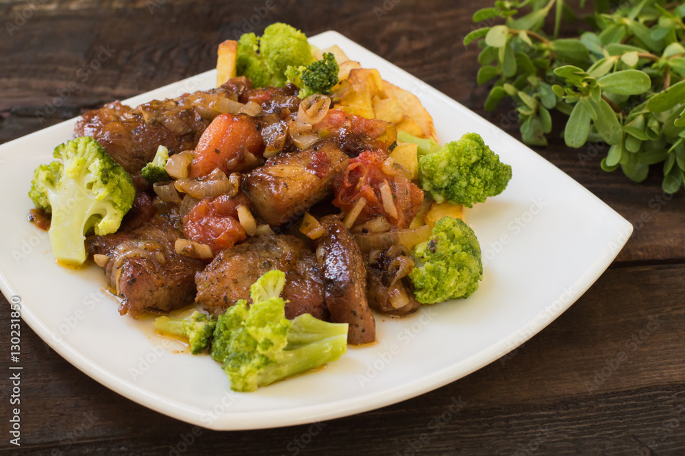 Stifado - a traditional Cypriot dishes, spread in Greece. It consists of stew with tomatoes, potatoes, broccoli, onions, garlic and spicy spices. Wooden rustic table. Top view. Close-up Stifado - a traditional Cypriot dishes, spread in Greece. It consists of stew with tomatoes, potatoes, broccoli, onions, garlic and spicy spices. Wooden rustic table. Top view. Close-up