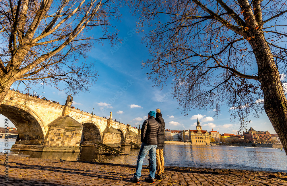 Obraz premium Couple of young people looking at Charles Bridge in Prague, Bohemia, Czech Republic