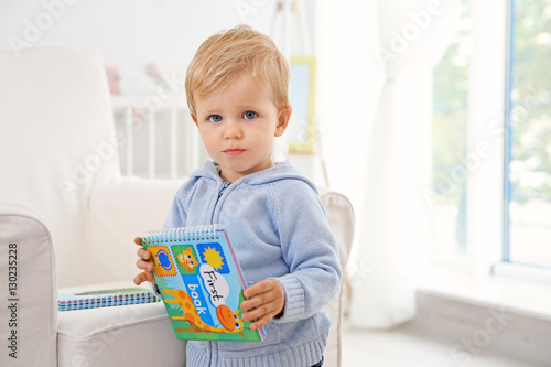 Cute baby boy holding a book