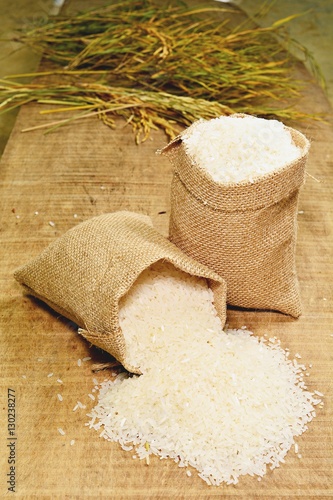 Rice in gunny bag on wooden surfaces in the side view.