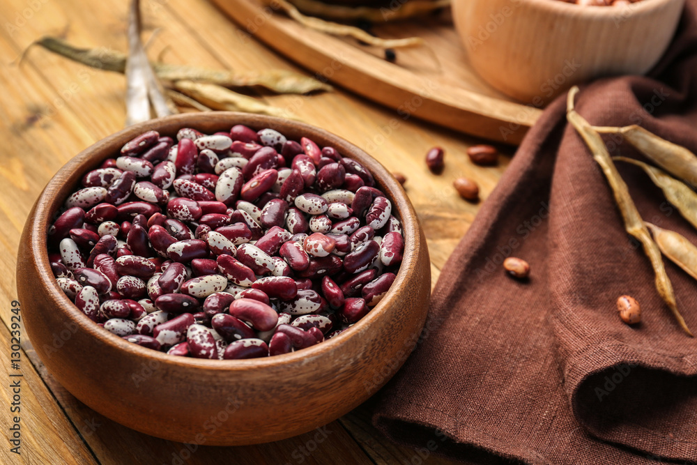 Bowl with dried haricot beans and napkin on wooden table Bowl with dried haricot beans and napkin on wooden table