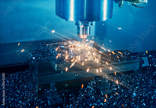 Milling machine working on steel detail with lot of sparks photo