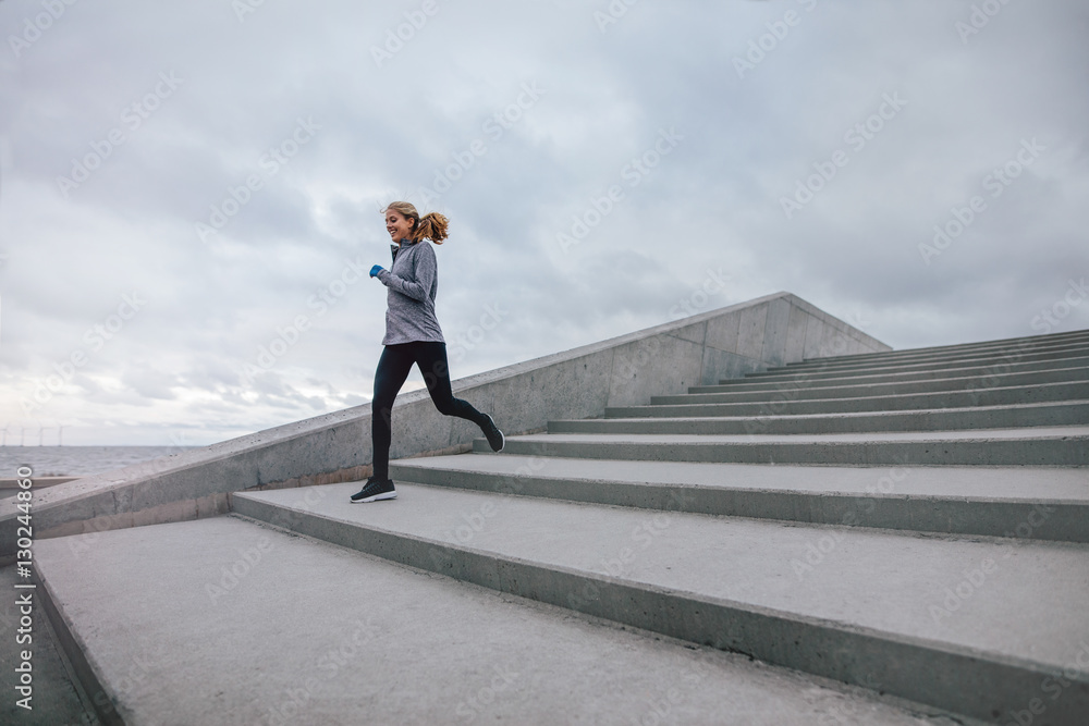 Fitness woman running down on steps Fitness woman running down on steps
