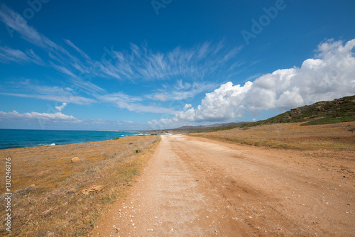 Road along the coast stretches to the clouds