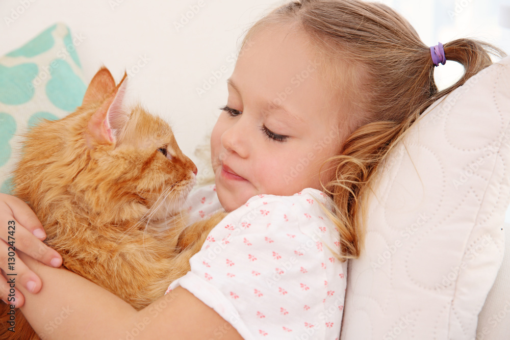 Cute little girl with red cat at home Cute little girl with red cat at home