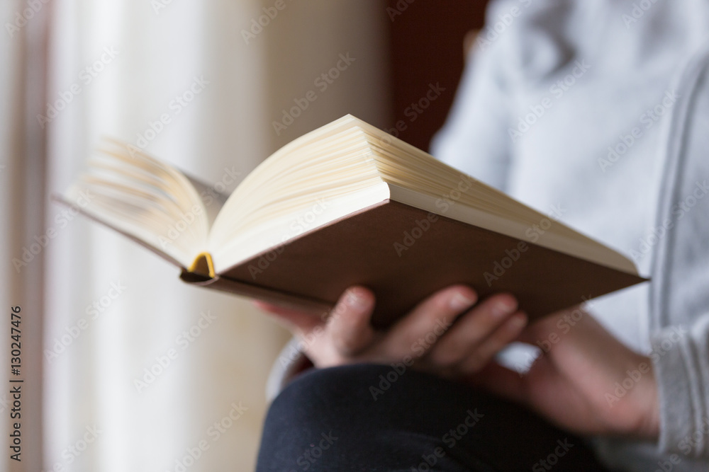 Fototapeta premium Mani femminili che reggono libro