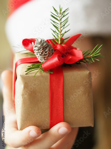 Christmas gift in the children's hands. Congratulations to the new year, gift presentation.