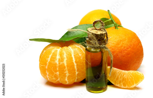 Mandarin, tangerine citrus fruit, with green leaf, isolated on white background. Cosmetic Essence, perfume oil natural plant product in a glass bottle.  Pile of a fresh citrus.