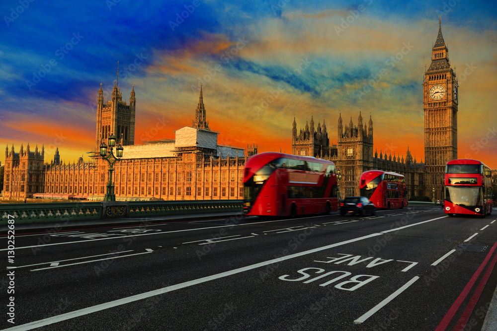 London, England, UK. Red buses blured in motion on Westminster bridge with Big Ben, the Palace of Westminster in early morning before sunrise.