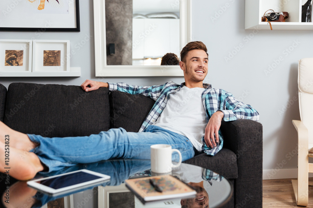 Happy bristle man lies on sofa and looking aside. Happy bristle man lies on sofa and looking aside.
