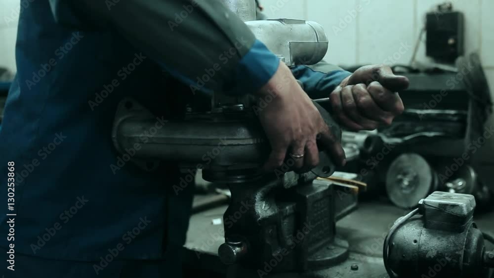 Auto mechanic repairs a turbocharger Auto mechanic repairs a turbocharger