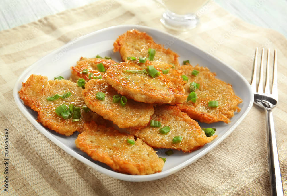 Plate with tasty potato pancakes for Hanukkah on kitchen table Plate with tasty potato pancakes for Hanukkah on kitchen table