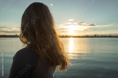 Girl Looking at Sunset Over Lake