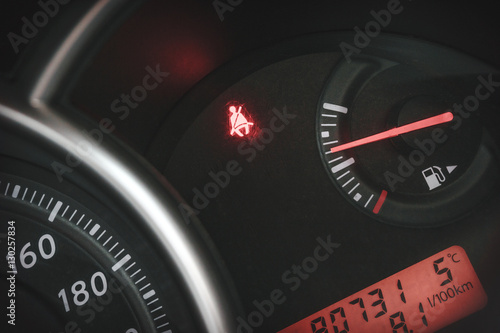 Car Dashboard or Console panel with Illuminated sign "belt is not fastened".