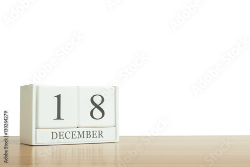 Closeup surface white wooden calendar with black 18 december word on blurred brown wood desk isolated on white background with copy space , selective focus at the calendar
