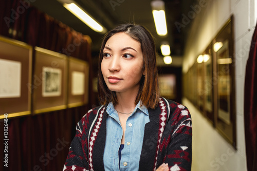 Fototapeta Visitor woman looks at the painting in art galery and thinking