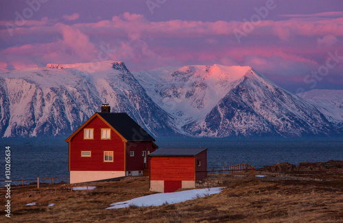 A red house in front of the mountains