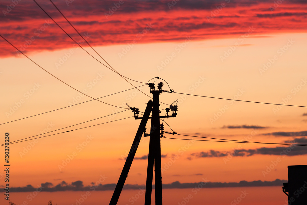 Electric line against colorful sky at sunset Electric line against colorful sky at sunset