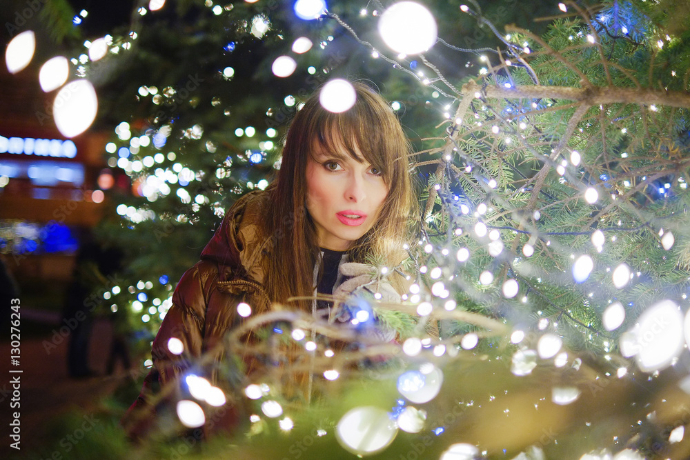 young woman with a tree and garlands, night portrait young woman with a tree and garlands, night portrait