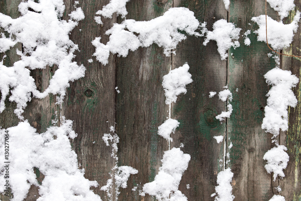 Fototapeta premium Snow on the wooden fence as a backdrop