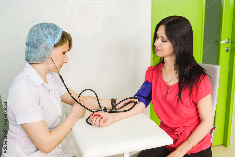 Obraz premium Nurse measures the patient blood pressure