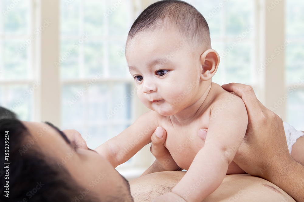 Cute baby stares at the father face Cute baby stares at the father face