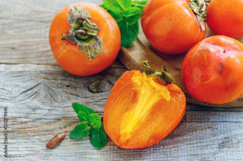 Foto Delicious persimmon fruit and mint.