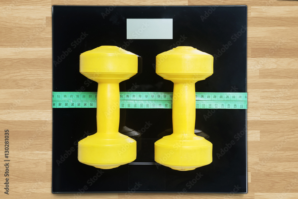 Dumbbells with measurement tools on wooden table Dumbbells with measurement tools on wooden table