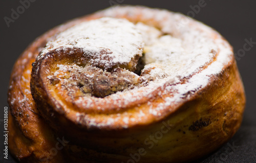 Closeup freshly baked cinnabon with powdered sugar coating, as seen from above, pastry concept photo