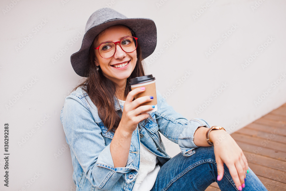 Young attractive hipster girl sits on terrace with coffee Young attractive hipster girl sits on terrace with coffee