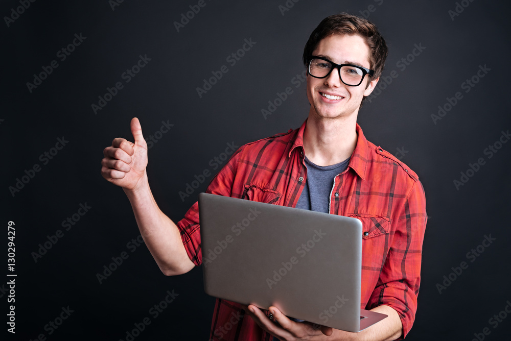 Cheerful student holding laptop Cheerful student holding laptop