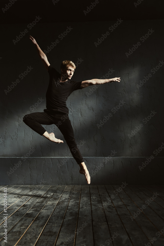 Concentrated young dancer performing the split in the air