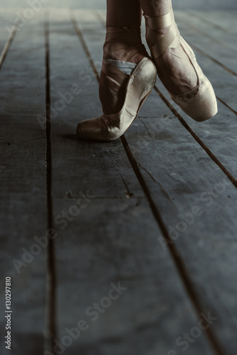 Ballet dancer stretching on tiptoes in the black room