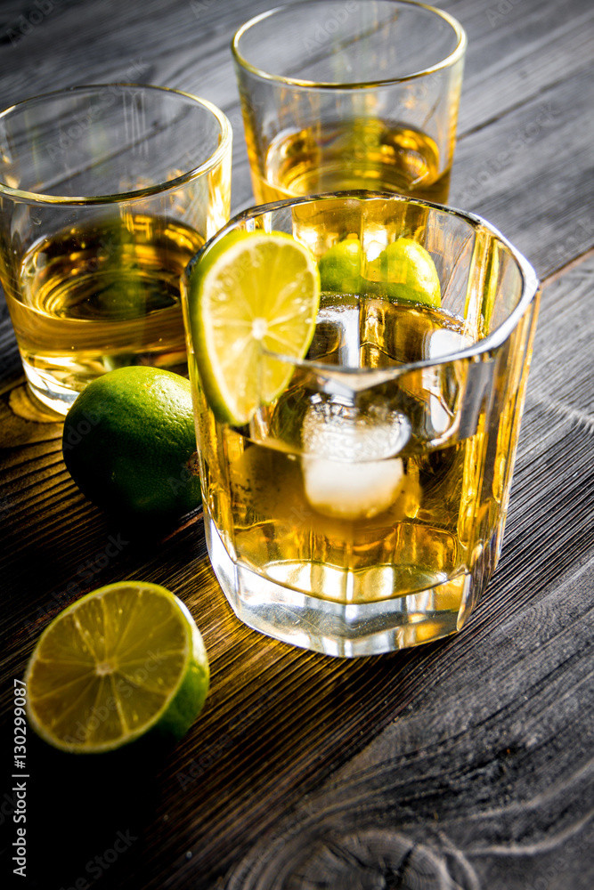 glass of whiskey on dark wooden background glass of whiskey on dark wooden background