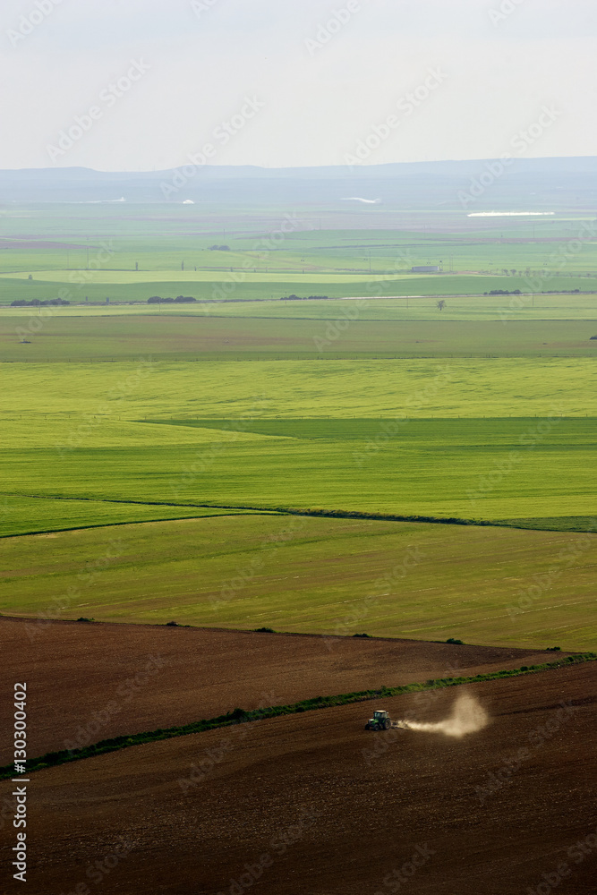 Aerial view of a tractor working a large farming area in Valladolid, Spain