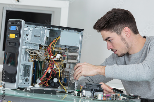 Young computer repairman at work
