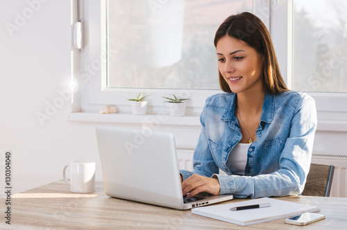 Beautiful young woman working on her laptop in her office.