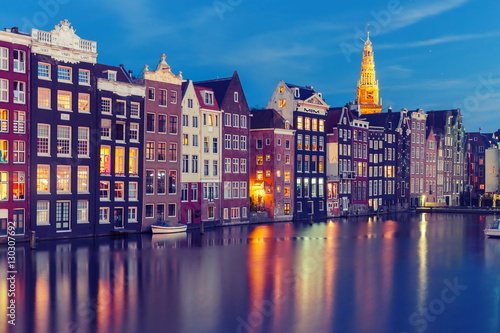 Amsterdam canal with typical houses and Oude Kerk church during twilight blue hour, Holland, Netherlands. Used toning
