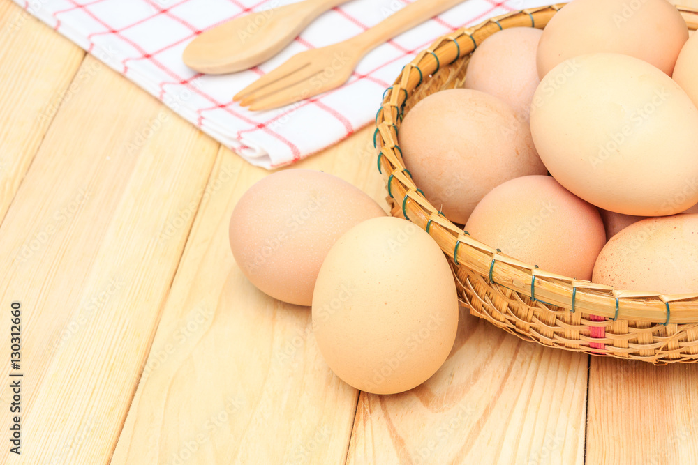 Fresh egg in the basket weaving over wooden table background, Top view with copy space and text. Fresh egg in the basket weaving over wooden table background, Top view with copy space and text.