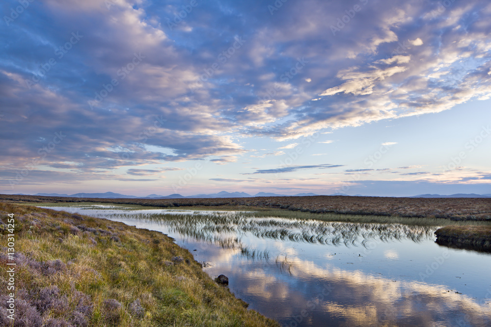 Evening reflections in a lochan on the peaty moreland of Lewis, with the mountains of Harris in the distance, Isle of Lewis, Outer Hebrides, Scotland Evening reflections in a lochan on the peaty moreland of Lewis, with the mountains of Harris in the distance, Isle of Lewis, Outer Hebrides, Scotland