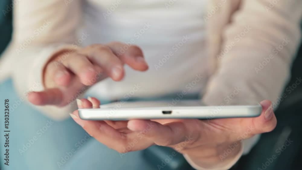 Woman using tablet on deck of cruise ship. Scrolling and touching. Sunrise light, golden hour. Close up shot of woman's hands with pad Woman using tablet on deck of cruise ship. Scrolling and touching. Sunrise light, golden hour. Close up shot of woman's hands with pad
